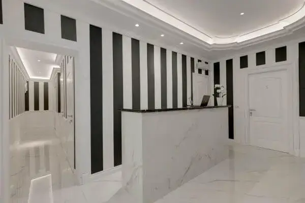 Reception del Boutique Hotel SM Vatican Relais con bancone in marmo e corridoio con porte e illuminazione moderna