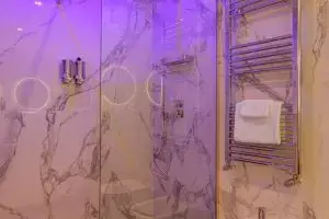 Doccia del Boutique Hotel SM Vatican Relais con illuminazione LED viola e rivestimenti in marmo
