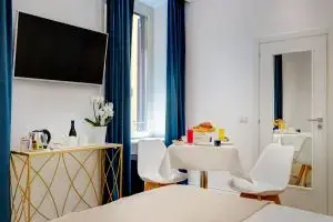 Area relax del Boutique Hotel SM Vatican Relais con tavolo colazione, TV e consolle decorativa