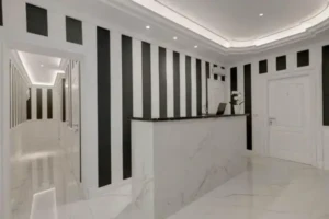 Reception del Boutique Hotel SM Vatican Relais con bancone in marmo e corridoio con porte e illuminazione moderna